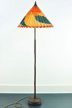 a lamp that is on top of a blue floor next to a white wall,