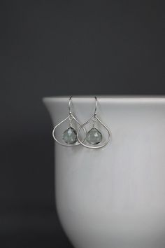 Sparkling faceted transparent Green Amethyst Quartz teardrop stones are wire wrapped with silver wire onto silver frame findings.  These dangle from silver earwires. Choose from balled silver earwires (as shown and sent with stoppers for the ends of the wires) or plain leverback earwires (these close in the back).  Beautiful everyday lightweight earrings in the most gorgeous color. Want these with a different stone?  Send me a message.  Silver frame links: 20x20mm Green Amethyst Quartz teardrops: 10x10mm Total length of earrings: 1 1/4" Measurements are approximate.  All silver is sterling.  A matching necklace can be made.  As the owner, maker, designer, and curator of this shop, I take great pride in providing you with jewelry that you will love to wear everyday, for special occasions, a Everyday Teardrop Gemstone Earrings, Everyday Gemstone Drop Earrings, Faceted Drop Earrings As Gift, Modern Teardrop Gemstone Earrings, Silver Briolette Earrings For Pierced Ears, Silver Briolette Earrings For Everyday, Elegant Everyday Gemstone Teardrop Earrings, Silver Teardrop Crystal Earrings For Everyday, Everyday Silver Teardrop Crystal Earrings