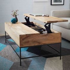 a coffee table with an open drawer underneath it in a living room area next to a couch