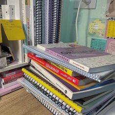 a stack of books sitting on top of a desk next to a pile of papers