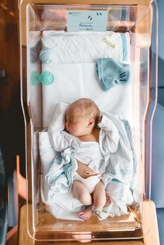 a baby is laying in a clear box