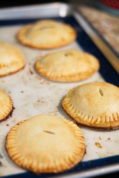 several small pies sitting on top of a baking sheet