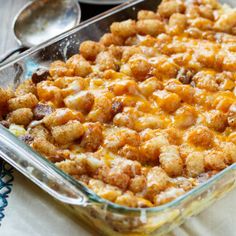 a casserole dish with tater tots in it and spoons on the side