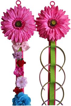 two flower vases with pink flowers and green ribbons attached to the top of them