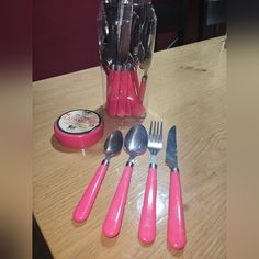 pink utensils and spoons are sitting on a table