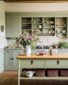 a kitchen with green cabinets and wooden counter tops