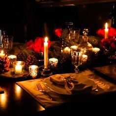 a table set with candles, plates and napkins for christmas dinner or special occasion