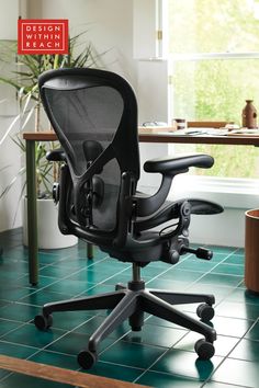 an office chair sitting on top of a green tile floor next to a potted plant