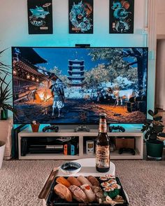 a flat screen television sitting on top of a tv stand next to a tray of food