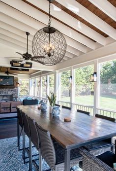 a large wooden table sitting under a chandelier