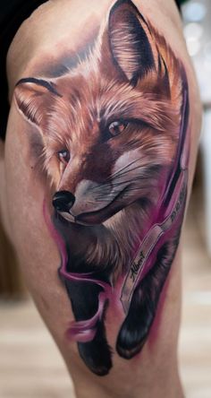 a close up of a person's thigh with a fox tattoo design on it