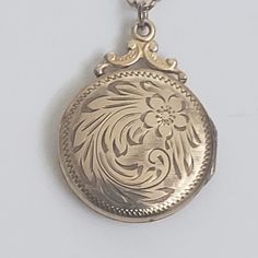 "Mid century round gold fill locket and chain with etched floral design. Personalized message on back, \"Peter and Jack Xmas '53. Locket closes with snap, Both the locket and chain are marked Gold filled 8. The locket is 1 3/8\" by 1\". The necklace length is 18\".  Previously owned and in good condition. There are minor signs of age/use. The pictures are part of the description.  Do browse our other items. We combine shipping for savings. International purchasers may wish to contact the shop for an accurate quote to the shipping address." Antique Yellow Gold Medallion Locket Necklace, Antique Style Yellow Gold Medallion Locket Necklace, Keepsake Medallion Locket Necklace With Hallmark, Gold Collectible Medallion Necklace, Vintage Gold Etched Jewelry, Vintage Gold Jewelry With Etched Details, Vintage Charm Medallion Necklace Gift, Gold Etched Locket Necklace For Keepsake, Antique Gold Engraved Medallion Necklace