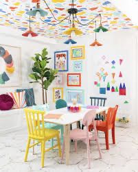 a room filled with lots of colorful furniture and art on the walls, including chairs