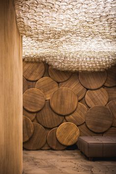 a room with wooden circles on the wall and a bench in front of it that is made out of wood