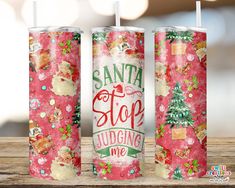 two christmas candles with santa's stop saying on them