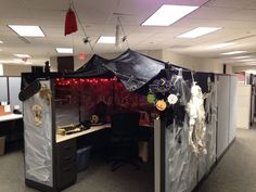 an office cubicle decorated for halloween with decorations on the walls and desks covered in plastic