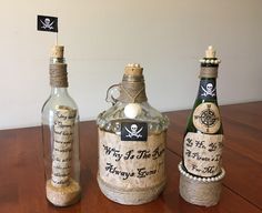 three bottles with labels on them sitting on a table