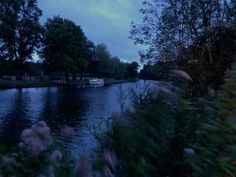 there is a boat that is on the water in the dark night time, and it appears to be going down the river