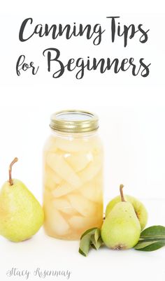 a jar filled with pears sitting next to two pears on top of a table