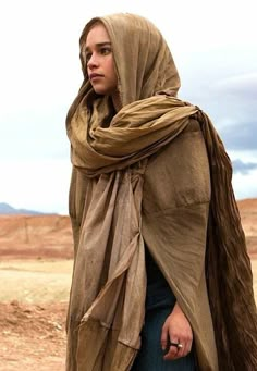 a woman wearing a brown shawl in the desert