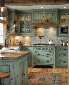 an old fashioned kitchen with green cabinets and wood flooring is pictured in this image