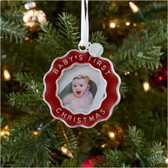 a baby's first christmas ornament hanging from a christmas tree