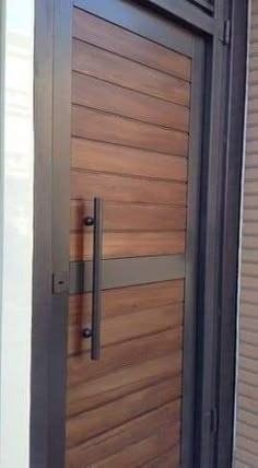 a close up of a wooden door with metal handles and bars on the outside wall