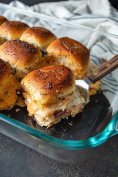 a glass casserole dish filled with ham and cheese sliders, ready to be eaten