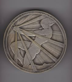 a silver medal with an image of a woman on it