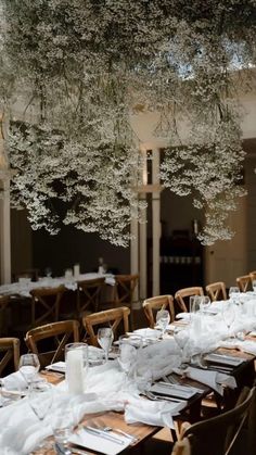 a long table is set with white linens and place settings