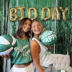 two girls are posing with basketballs in front of a green and gold birthday backdrop