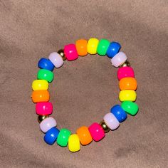 This Is Made With Rainbow Pony, Beads, And Gold Separator Beads. Playful Orange Beaded Bracelets With Letter Beads, Rainbow Plastic Jewelry With Colorful Beads, Rainbow Colorful Beads Plastic Jewelry, Playful Rainbow Stretch Bracelet With Round Beads, Fun Rainbow Beaded Bracelets, Colorful Plastic Beads For Gifts, Cute Rainbow Stretch Bracelet With Colorful Beads, Fun Rainbow Beaded Stretch Bracelet, Playful Rainbow Beaded Bracelets With Round Beads