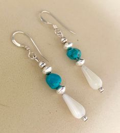 These earrings are made from beautiful, blue pebble sized genuine turquoise and mother of pearl teardrops with sterling silver beads. These classic earrings will go with just about everything! Turquoise is thought to have healing, luck and communication properties. Options:  we offer over 17 different gorgeous gemstones to choose from to create your new favorite earrings. 1 1/4 in length  Genuine turquoise pebble gemstones  All sterling silver components and beads Sterling silver French ear wire Pearl And Turquoise Earrings, 2022 Jewelry, Blue Gemstone Earrings, Tiffany And Co Jewelry, Beaded Earrings Diy, Diy Jewelry Unique, Mother Of Pearl Earrings, Classic Earrings, Beaded Drop Earrings