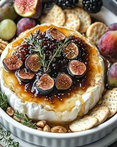 a platter filled with cheese, crackers and figs on top of it