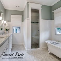 a bathroom with a claw foot tub and white cabinets