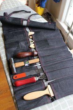 several different types of kitchen utensils are lined up on a table with a cloth