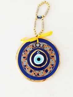 ⭐️Diameter of the blue evil eye bead is 14 cm(5.5 in) ⭐️Height of the blue eye wall charm is 28 cm(11 in) ⭐️Evil eye hanging is gold plated. There are two blue glass beads on the hanging. ⭐️Evil eye bead is painted. ⭐️ Evil Eye is totally handmade. ⭐️The evil eye bead is large and it is perfect for home decoration. ⭐️Turkish eye decor is also gold plated. It is believed that evil eye charm protects you from the evil eyes. Evil eye charm is over 5000 years old. It is found in all major religions Handmade Blue Jewelry For Blessing, Blue Evil Eye Bracelet With Round Beads For Festivals, Handmade Blue Evil Eye Bracelet For Festival, Traditional Blue Evil Eye Jewelry, Handmade Blue Evil Eye Bracelet For Good Luck, Blue Evil Eye Bracelet For Festivals, Evil Eye Hanging, Nazar Amulet, Wall Charm