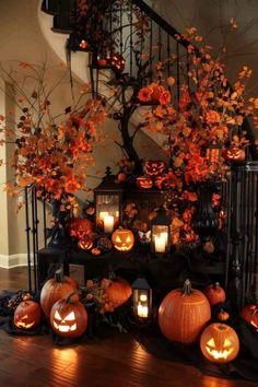 halloween decorations with pumpkins and candles in front of a spiral stair case on the floor