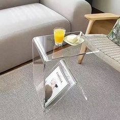 a glass table sitting on top of a carpeted floor next to a white couch