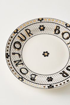 a white plate with black and gold designs on the rim that says bourbon city,