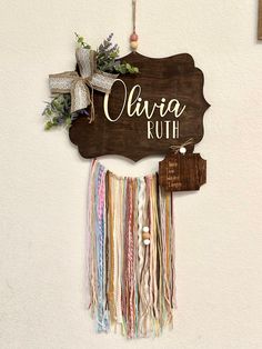 a wooden sign hanging from the side of a wall next to a bunch of ribbons