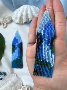 someone is holding some beaded earrings in their hand and it looks like they are made out of beads