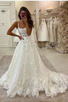 a woman taking a selfie while wearing a wedding dress in front of a mirror