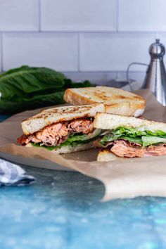 a sandwich cut in half sitting on top of a cutting board