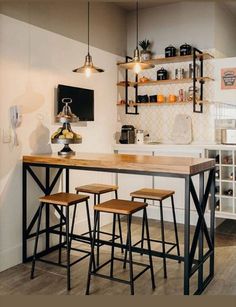 a kitchen with three stools and a table