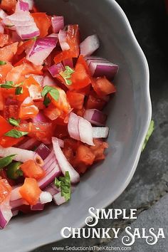 a close up of a bowl of food with onions and carrots in it on a table