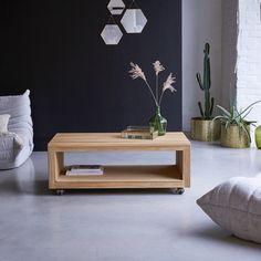 a living room filled with furniture and plants on top of a coffee table in front of a brick wall