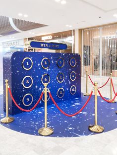 a blue and gold display in the middle of a room with red ropes around it