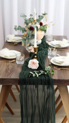 the table is set with candles, plates and napkins on top of each other