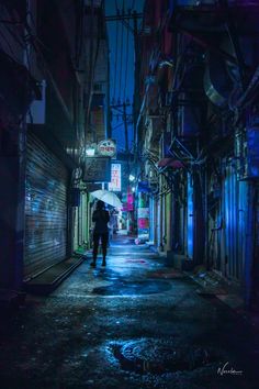 a person holding an umbrella walking down a dark alleyway in the city at night